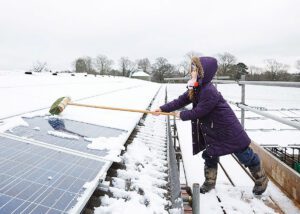 Young_girl_cleaning_photovoltaic_solar_panels